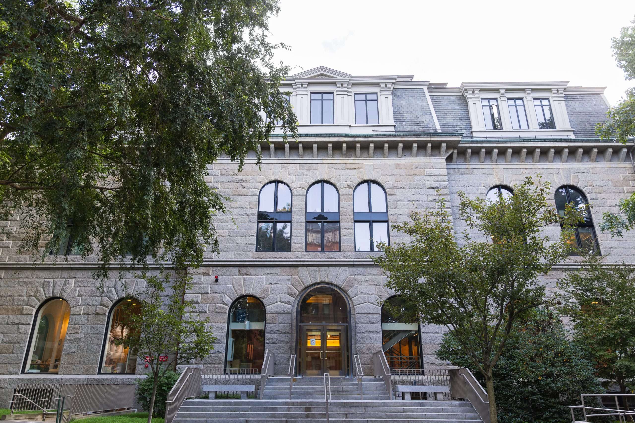 A brick building is featured atop a set of steps at Harvard University.